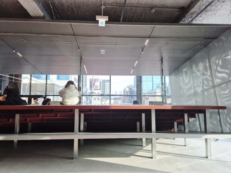 Intérieur du café du 3ème étage - Espace avec tables en gradins