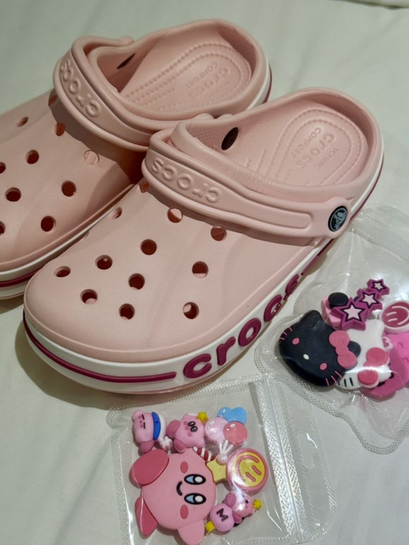 Zeigen der pinken Crocs