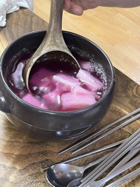 Essen von Dakgalbi in Salatblatt in Chammi Dakgalbi