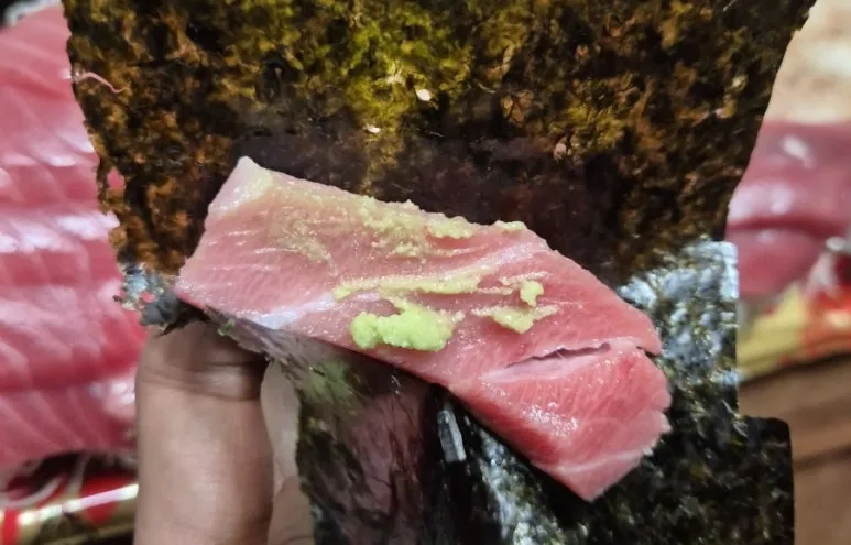 Dégustation de l'Akami avec du wasabi sur une feuille d'algue nori.